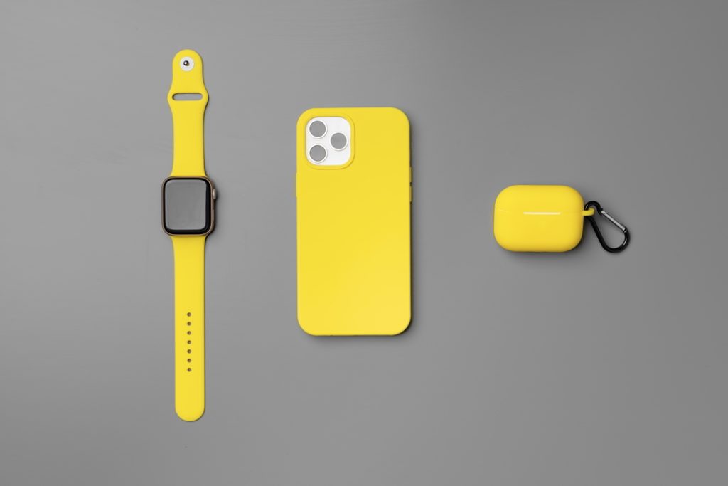 yellow smartwatch, smartphone and earbuds